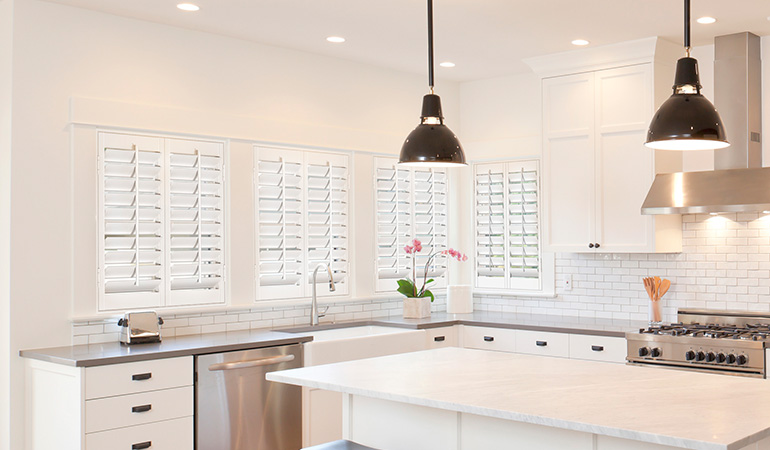 White Polywood shutters in a large and modern kitchen.