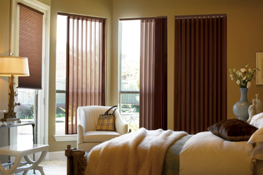 Choose durable and high-quality fabric or vinyl vertical blinds in San Diego. Maroon fabric vertical blinds inside a bedroom