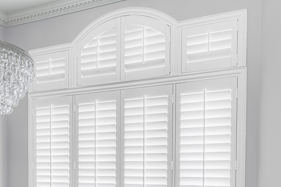 Customize your Palladian windows with white Polywood shutters in San Diego. White Polywood Palladian windows in a dining room.