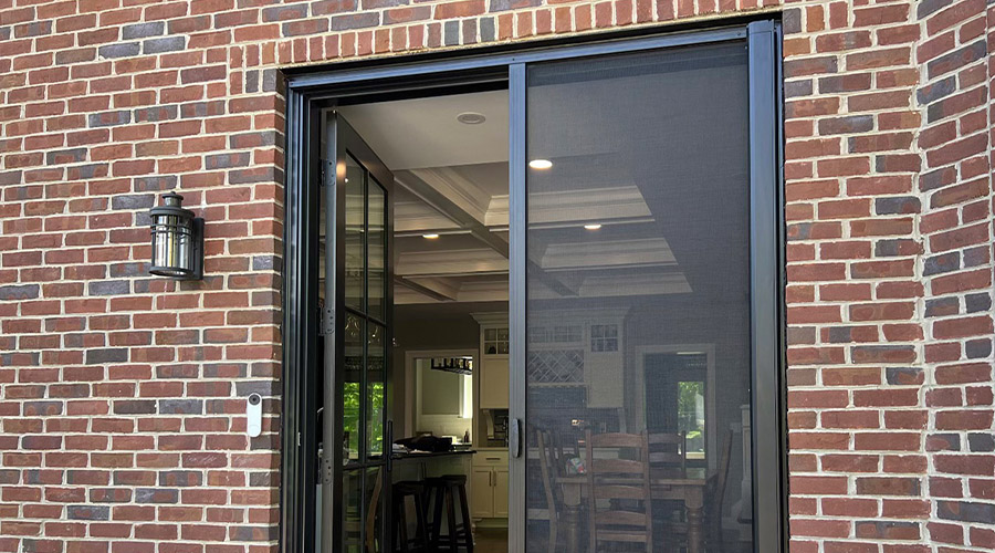 A black retractable screen on a black French door