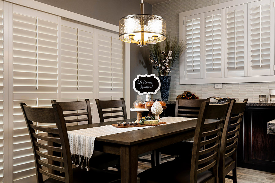 Faux wood plantation shutters covering doors and windows within dining room