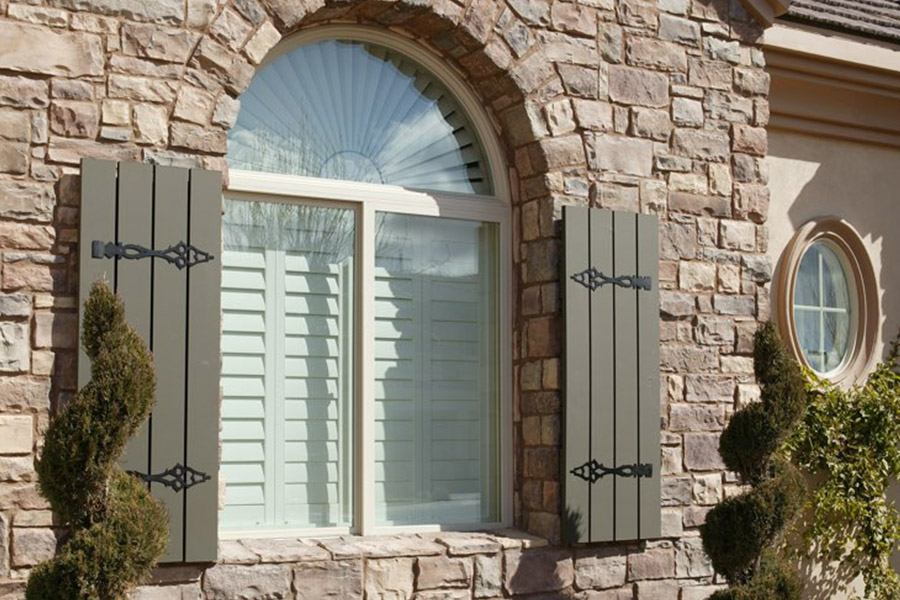 Exterior shutters displayed with interior white Polywood shutters.