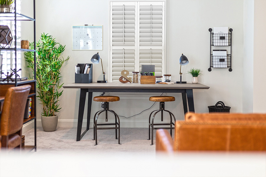 A home office with white Polywood shutters