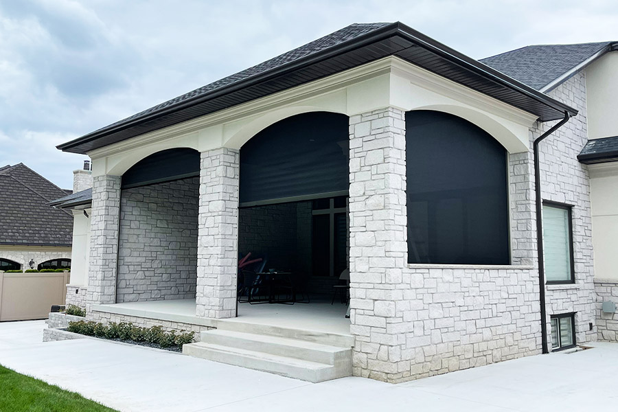 Black retractable motorized screens around a porch patio