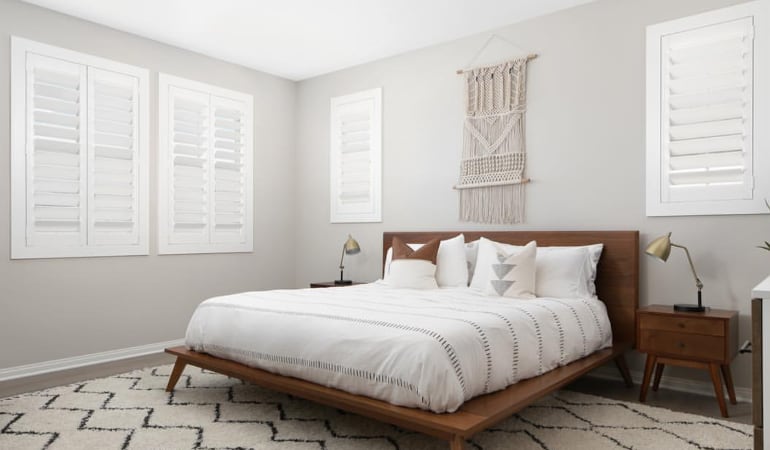 Open shutter louvers will help any San Diego room feel larger. Plantation shutters in a model home bedroom.