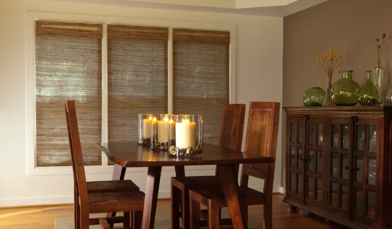 Add a hint of nature to your decor using woven shades. Woven shades in a dining room window.