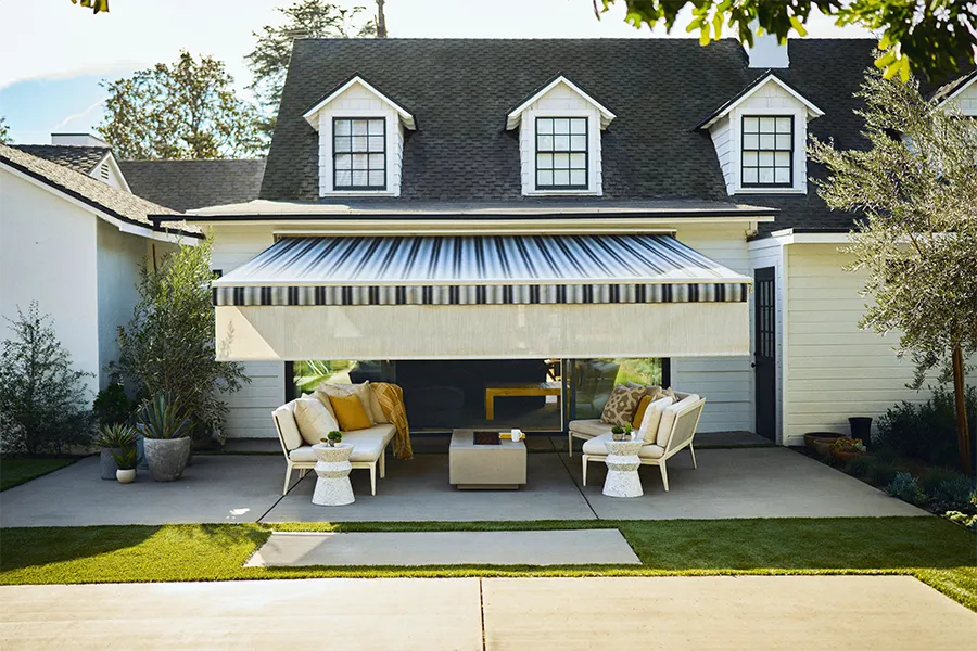 Add a front screen to your awning for even more shade A black and white striped awning with a white front screen over a white stone patio