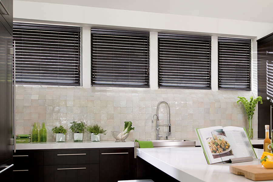 Choose custom Polywood faux wood blinds for your kitchen in San Diego. Special shaped faux wood blinds in several windows above a sink.