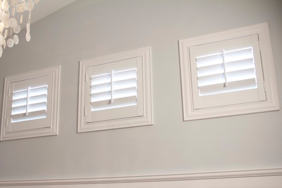 Plantation shutters offer superior light control and ventilation options for casement windows like these. Three casement windows covered by custom plantation shutters.