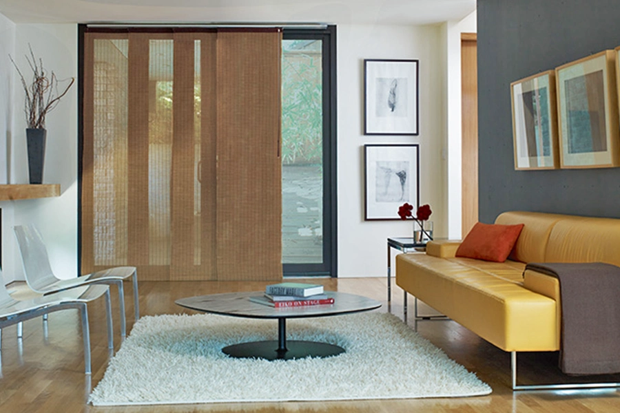 Fabric panel track window treatments are a sleek, stylish option for sliding glass doors. Panel track fabric window treatment covering a sliding glass door in a stylish living room