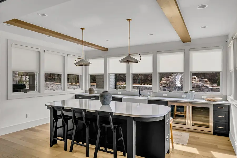 White motorized roller shades on windows in a stunning kitchen and dining area