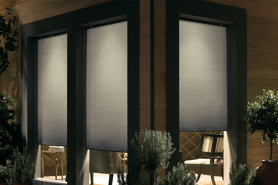 Cellular shades are modern and stylish window treatments for your home in San Diego. Dark gray cellular shades displayed from the exterior of a home.